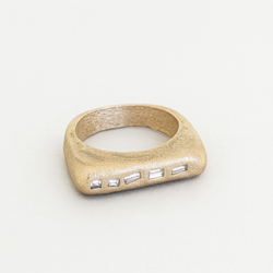 Gold ring with embedded stones on a light gray background