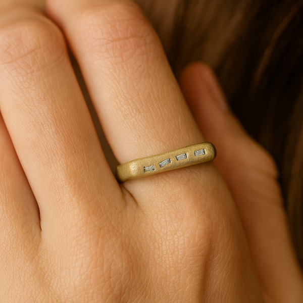 Close-up of a hand wearing a gold ring with engraved text.