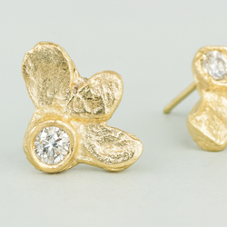 Gold butterfly earrings with clear gemstones on a light gray background