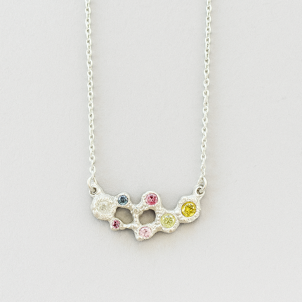 Necklace with multicolored gemstones on a light gray background