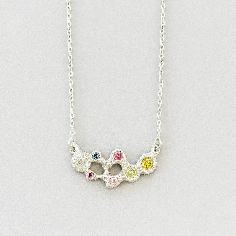 Necklace with multicolored gemstones on a light gray background