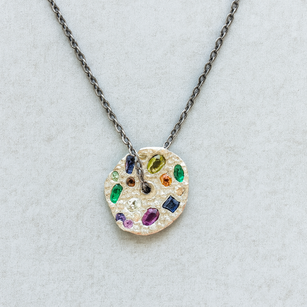 Necklace with a colorful gemstone pendant on a light gray background
