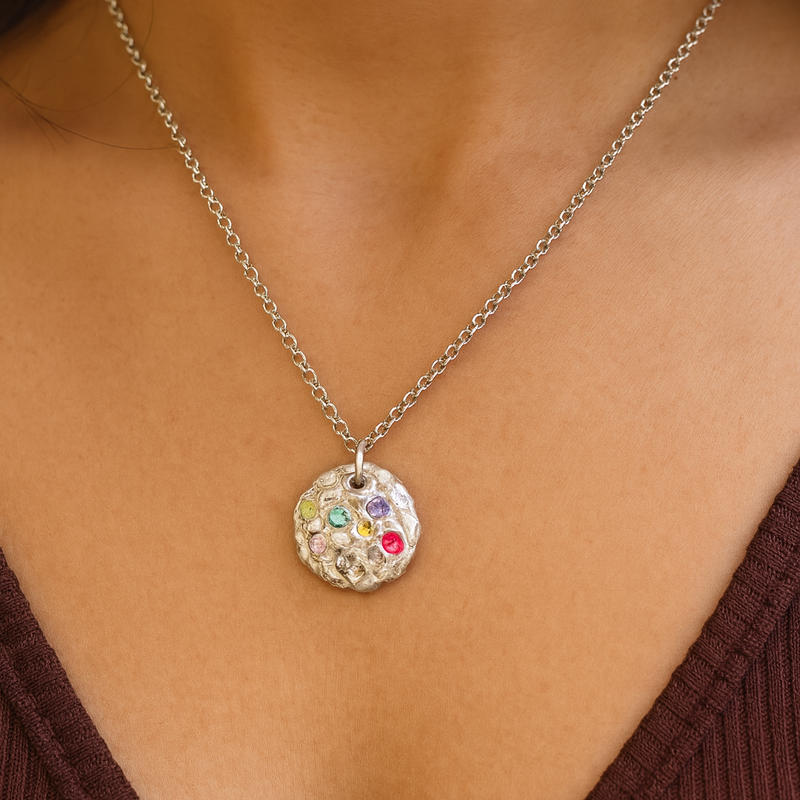 Necklace with a colorful pendant on a person wearing a brown top